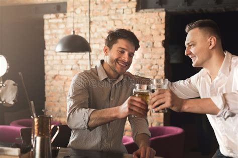 Two Happy Young Men Talking And Drinking Beer At Bar Stock Image