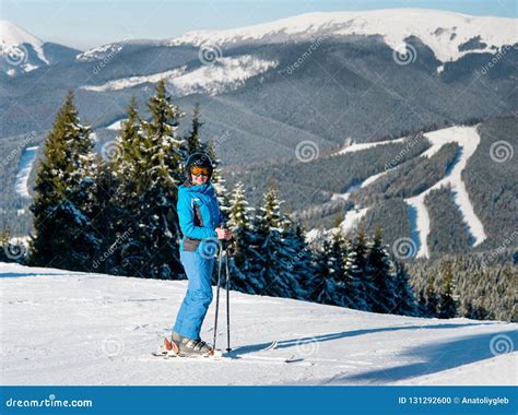 Full Length Shot Of A Happy Woman Skier Skiing On The Slope At Winter Ski Resort In Sunny