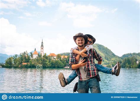 Happy Couple Of Tourists In Love Standing On A Wooden Pier On The