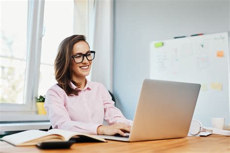 Smiling Young Woman Working In Office With Laptop Smartsys