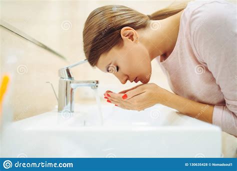 Woman Washes Her Face At The Sink In Bathroom Stock Photo Image Of