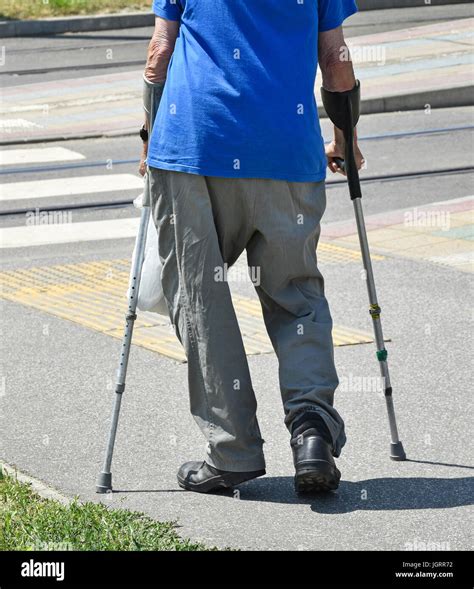 Old Man Walks With Crutches Stock Photo Alamy