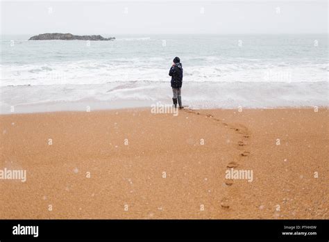 Teenage Boy Standing On Snowy Winter Ocean Beach Stock Photo Alamy