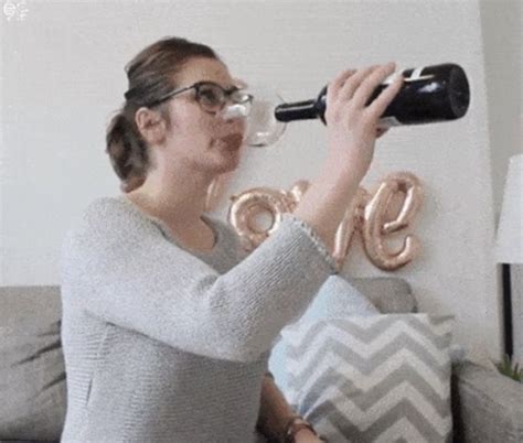 a woman sitting on a couch drinking from a wine glass with the word love spelled out