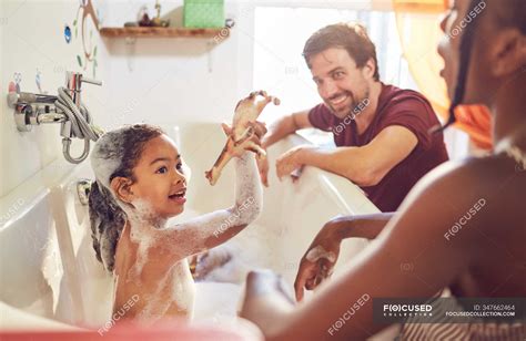 Parents Giving Daughter Bubble Bath Smiling Fun Stock Photo