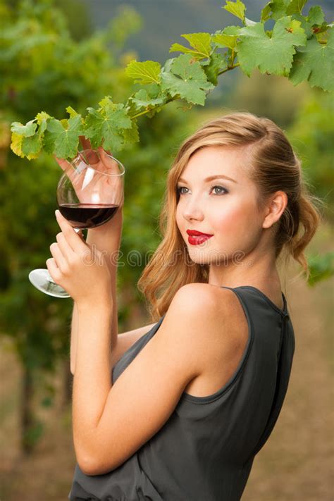 Attractive Stylish Woman Drinking Glass Of Red Wine In Vineyard Stock