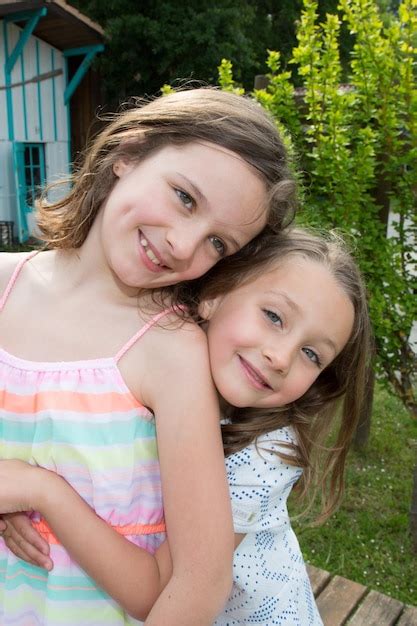 Deux Petites Soeurs Heureuses Aiment Et S Embrassent Dans Un Magnifique Parc Photo Premium