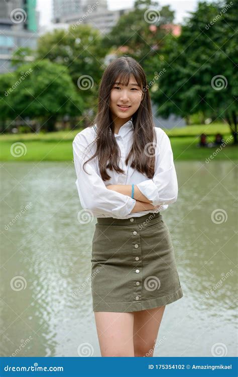 Happy Young Beautiful Asian Teenage Girl Smiling With Arms Crossed At
