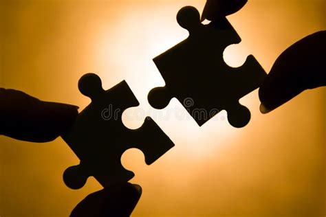 Hands Trying To Fit Two Puzzle Pieces Together Stock Photos Free