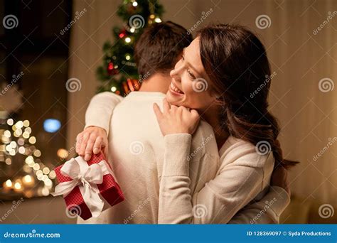 Happy Couple With Christmas T Hugging At Home Stock Image Image Of