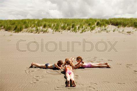 Girls Lying On Sand At Beach Stock Image Colourbox