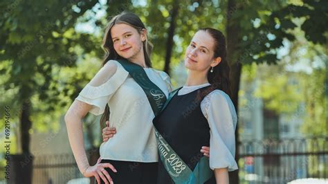 Russian Girls Graduate Posing With A Flyer And Inscription Graduate 2023 On Graduation Day