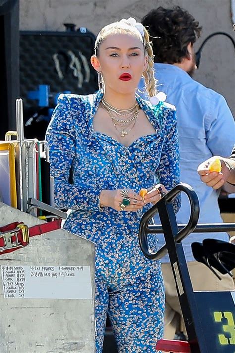 Miley Cyrus In A Blue Floral Jumpsuit On Set Of Her Latest Project In