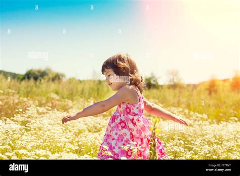 Happy Little Girl Walks On The Flower Field Stock Photo Alamy