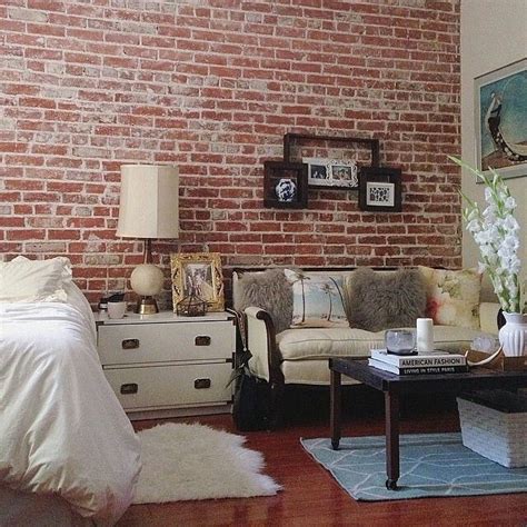 A Living Room Filled With Furniture And A Brick Wall Behind The Couch