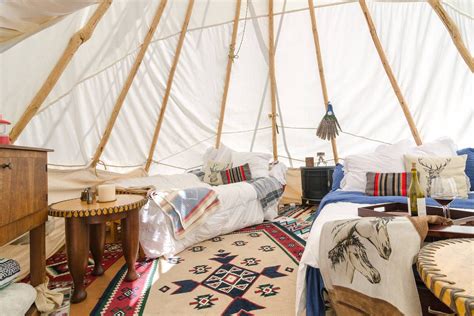 The Inside Of A Yurt With Several Beds And Rugs On The Floor In Front Of It
