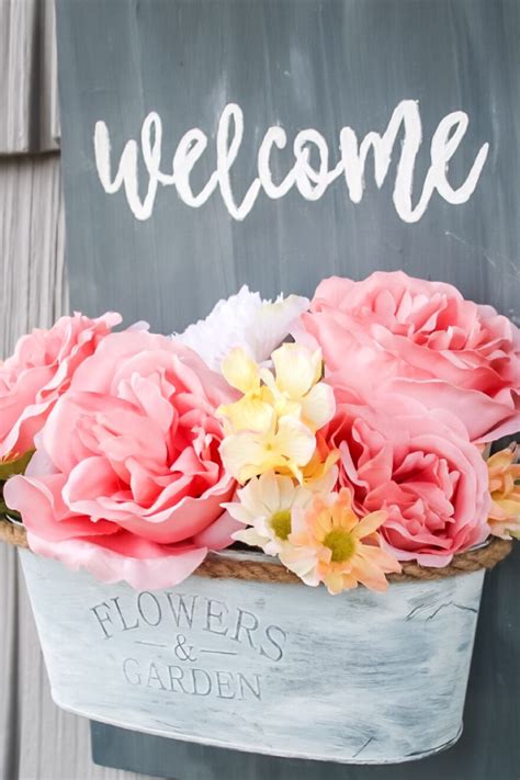 A Welcome Sign With Pink And Yellow Flowers