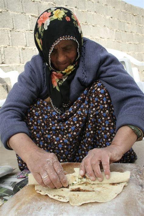 senior woman making pastry for traditional food gozleme inside rustic kitchen of old turkish