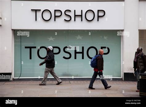 People Walk Past The Shop Front To High Street Fashion Chain Store