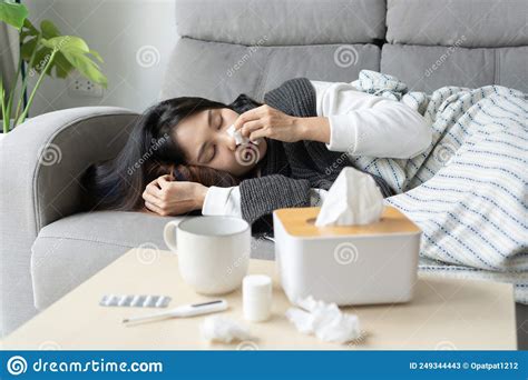 Upset Young Asian Woman Sleeping On Couch Covered With Blanket Freezing