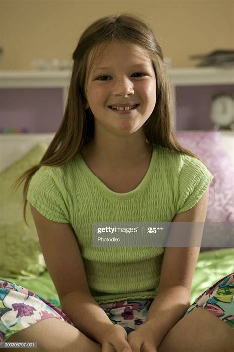Young Girl Sitting On Bed Crossing Legs Closeup Stock
