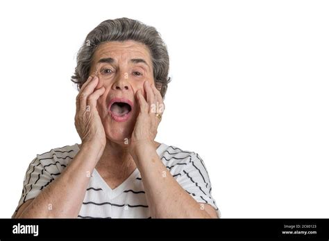 Elderly Lady With Hands On Cheeks Looking At Camera With Open Mouth