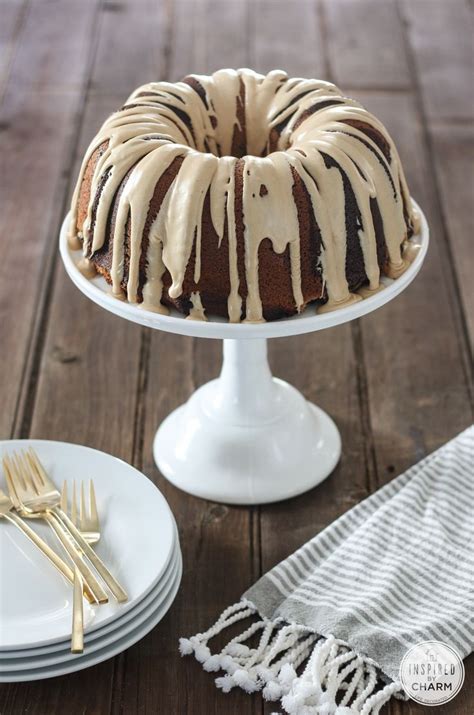 A Bundt Cake Sitting On Top Of A White Cake Stand Next To Plates And Forks