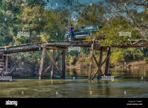 Tourist With Car On A Large Rickety Wooden Bridge In The Middle Of The