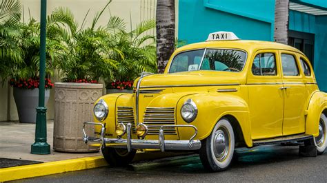 Photo Of Yellow Taxi Parked Near Sidewalk · Free Stock Photo