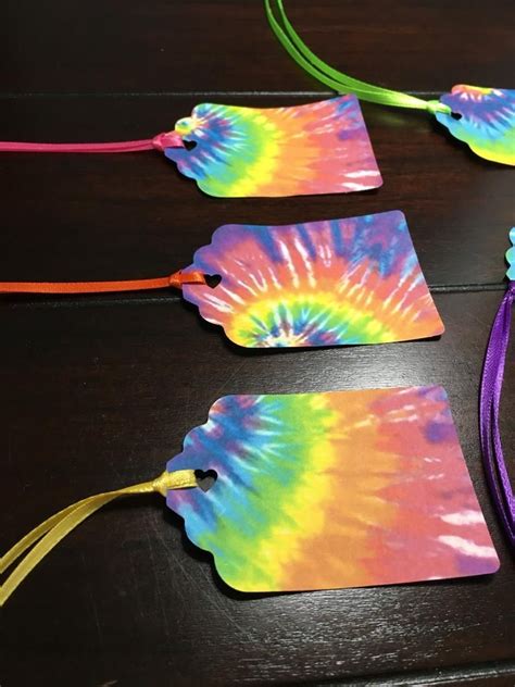 Four Tags With Colorful Tie Dye On Them Are Sitting On A Table Next