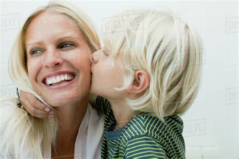Boy Kissing His Mother On The Cheek Stock Photo Dissolve