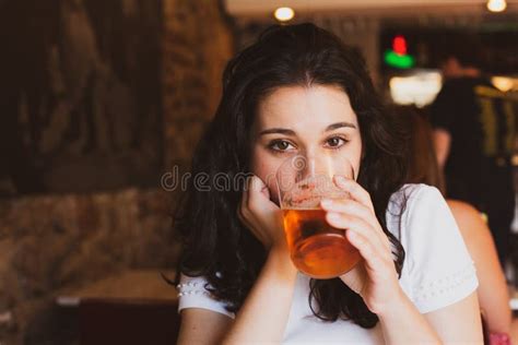 Young Beautiful Woman Drinking Beer In A Glass In A Bar Stock Photo