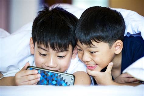 Asian Preschool Boys Playing On Smartphone Together Stock Image Image