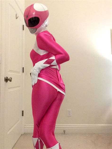 a woman in pink and white costume standing next to a door