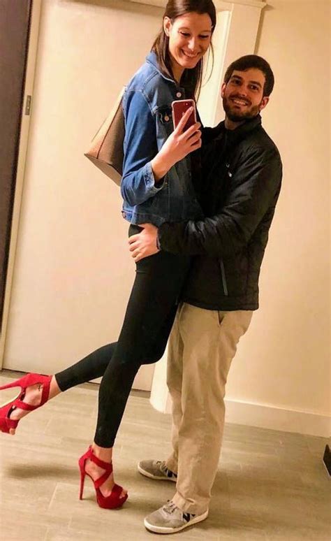 A Man And Woman Taking A Selfie In Front Of A Mirror With Red Shoes