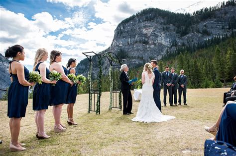 A Bride And Groom Standing In Front Of Their Wedding Party At The Top