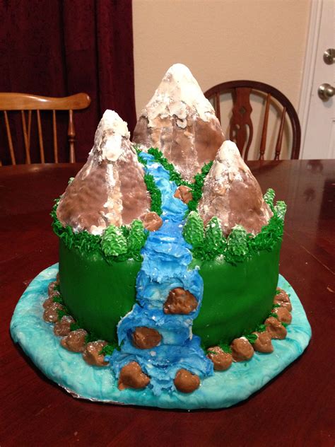 A Cake Shaped Like A Mountain With A River Running Through It On Top Of