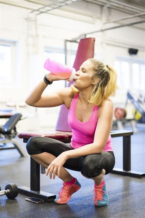 Caucasian Blonde Scandinavian Fitness Girl Training At Gym Drinking