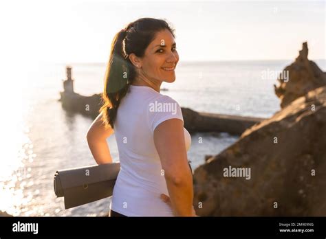 A Woman With The Yoga Mat In Nature By The Sea At Sunset Healthy And