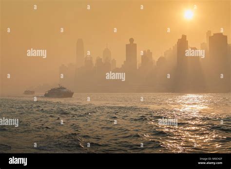 Golden Smog Polluted Sunrise Over Victoria Harbour With Morning Ferrys