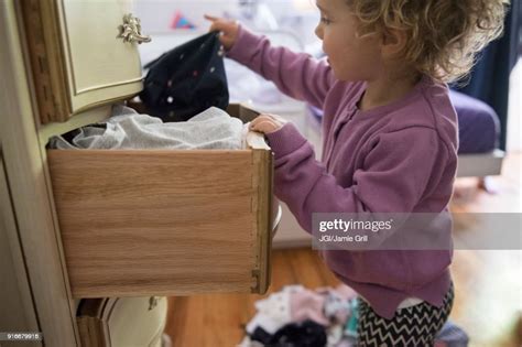 Caucasian Girl Removing Clothing From Dresser Drawer Photo Getty Images