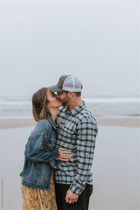 couple kissing on beach by stocksy contributor leah flores stocksy
