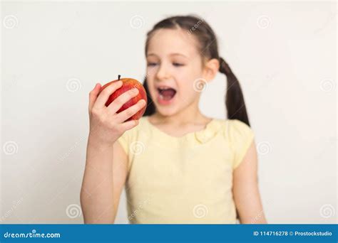Pretty Cute Little Girl Biting Red Apple Over White Background Stock