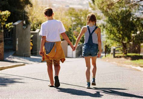 Boy And Girl Walking On An Empty Road Together Kids In Love Walking On