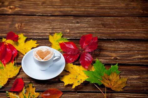 Photo Of Cup Of Coffee And Autumn Leaves On The Wonderful Brown Stock