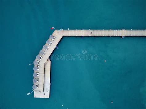 Aerial View Of A Beach Dock With People Walking Along The Waterfront