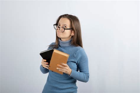Retrato De Uma Mulher Em óculos Segurando Dois Livros Sobre Fundo