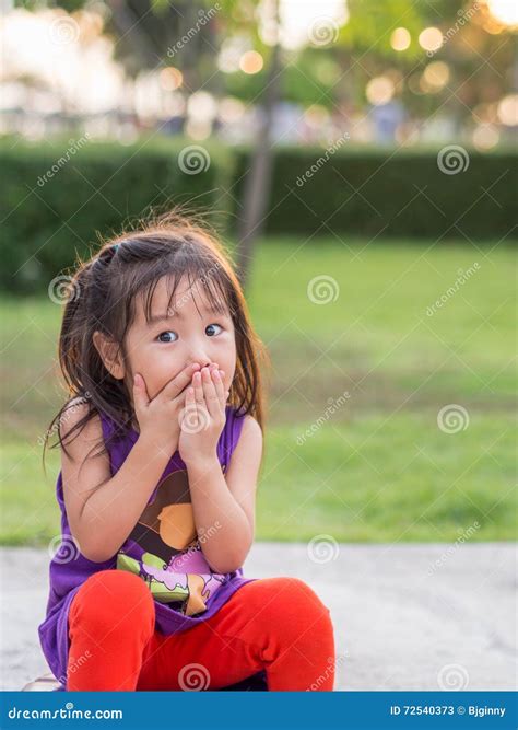 Little Asian Girl Covering Her Mouth With Her Hands Stock Image Image Of Girl Hand 72540373