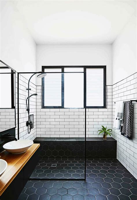 A Black And White Tiled Bathroom With Two Sinks