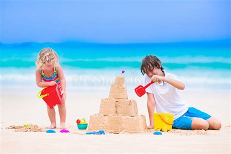 Adorable Kids Building Sand Castle On A Beach Stock Photo Image Of